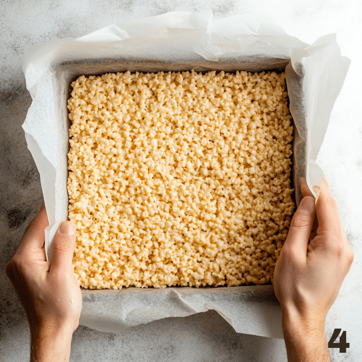 Placing the top rice krispie layer over the vanilla ice cream to complete the rice krispie ice cream sandwich