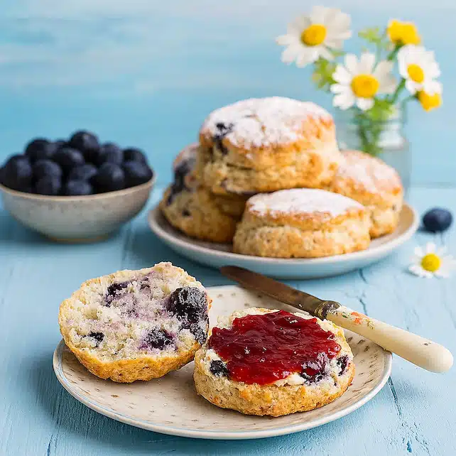 Freshly baked blueberry lemonade scones served with jam and butter Freshly baked blueberry lemonade scones served with jam and butter