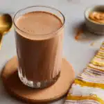 Chocolate-Peanut Butter Protein Shake in a glass with banana and cocoa