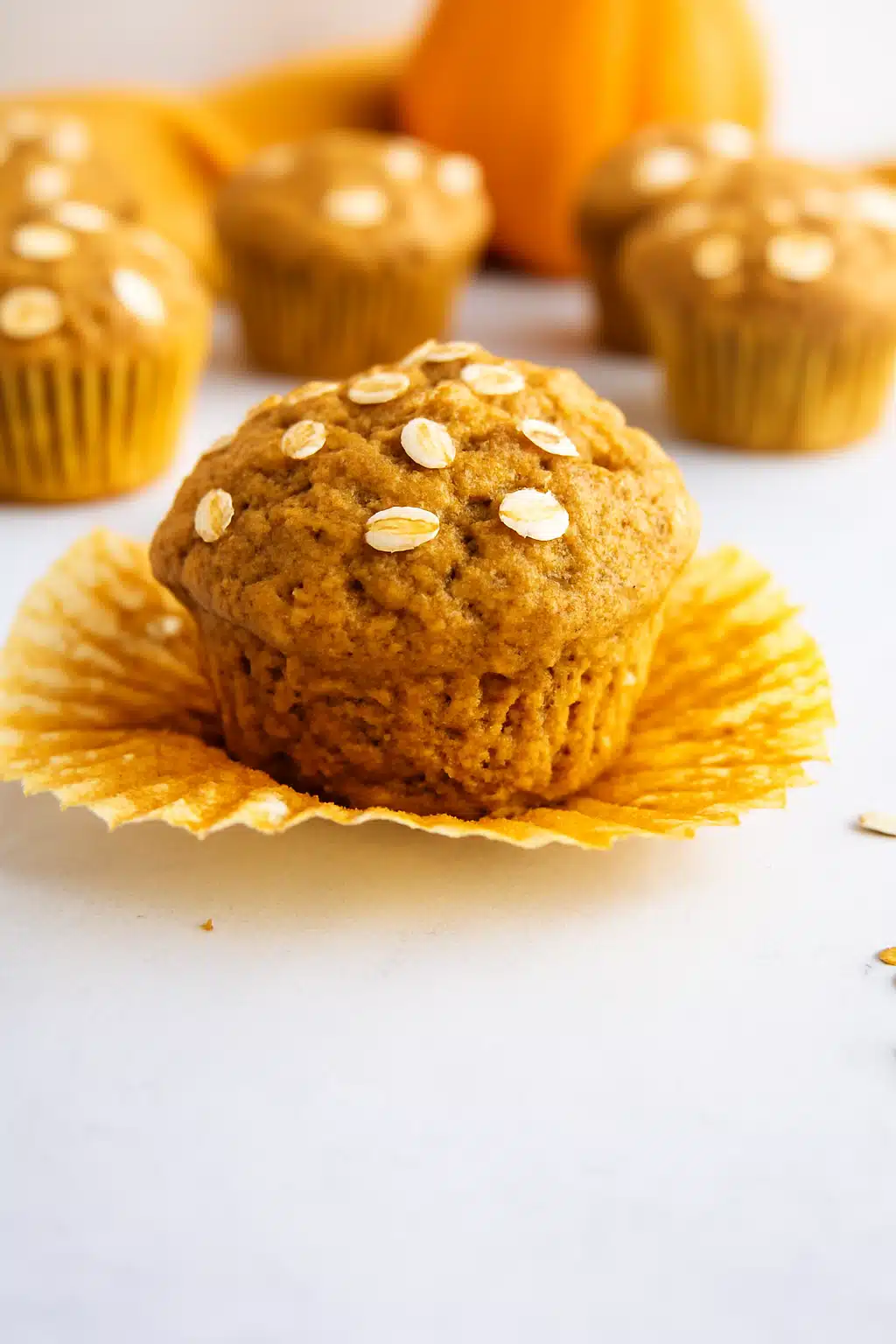 Healthy maple pumpkin muffin close-up topped with oats