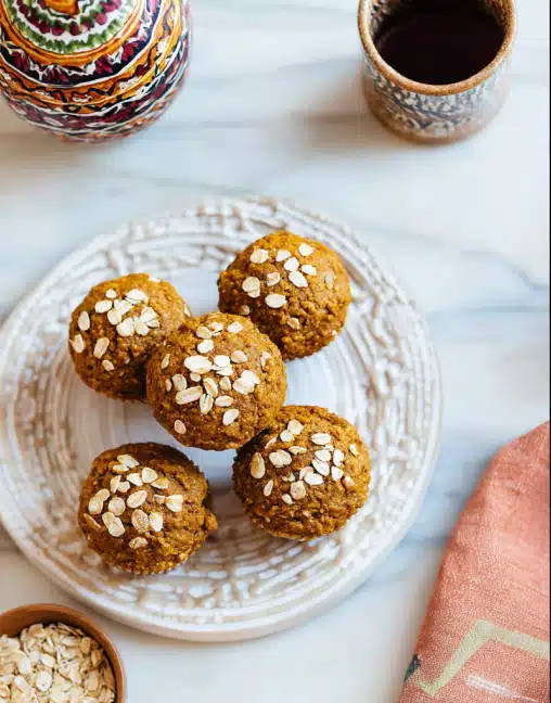 Healthy maple pumpkin muffins on a plate topped with oats