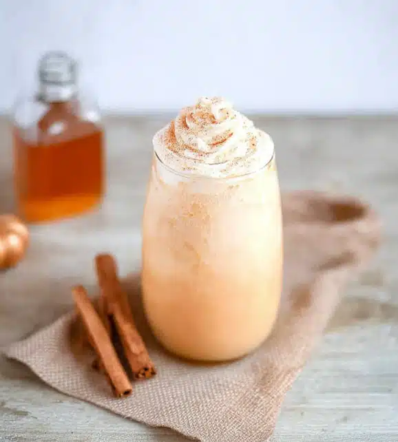 Pumpkin spice milk in a glass mug with whipped cream topping