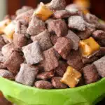 chocolate caramel apple puppy chow in a glass bowl