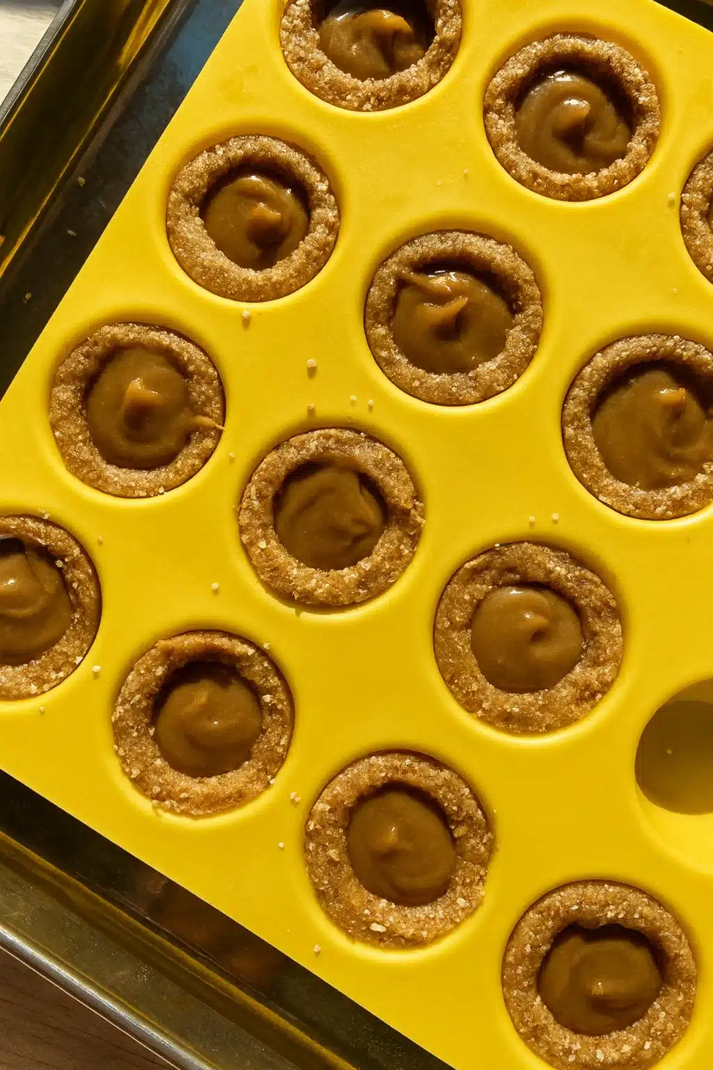 Caramel-filled healthy Twix cookie cups in a yellow silicone mold