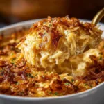 French onion chicken orzo casserole topped with melted cheese and fresh herbs.