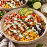 Delicious chicken fajita bowls topped with cilantro lime crema and fresh vegetables